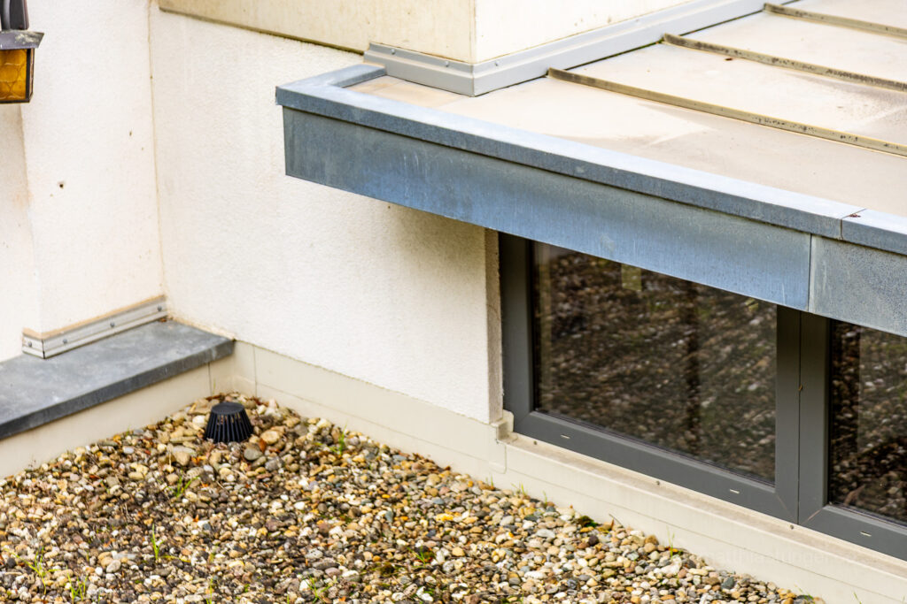 Abschlusskante eines Falchdaches mit Metall und Fenstereinbau