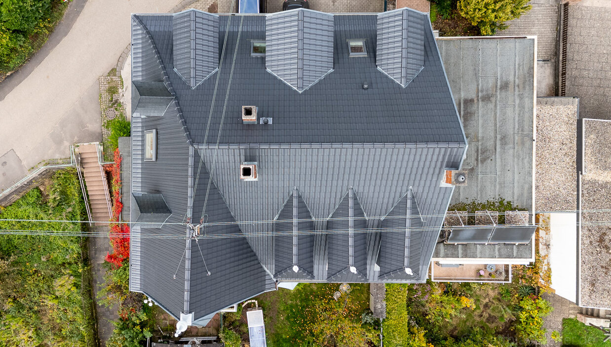 historisches Dach, mittig von oben mit einer Drohne aufgenommen, anthrazit mit vielen Details und Gauben komplett mit Zigeln eingedeckt