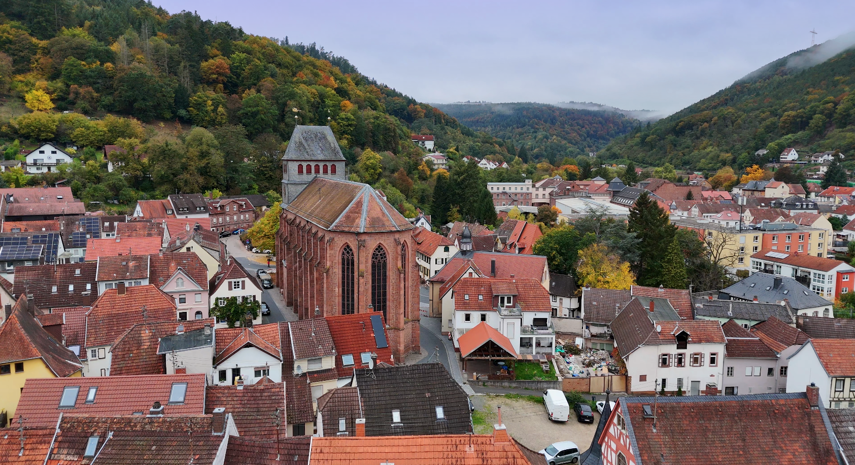 Lambrecht,Drohnenaufnahme mit Kirche und Blick ins Tal über die Hausdächer hinweg