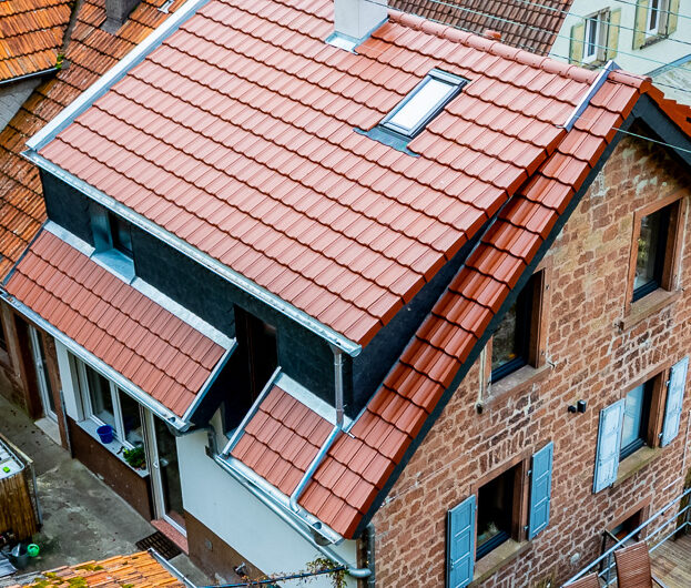 Ein traditioneles Haus wurde modern neu eingedeckt, die drohneneaufnahme zeigt das Huasdach auf der Rückseite